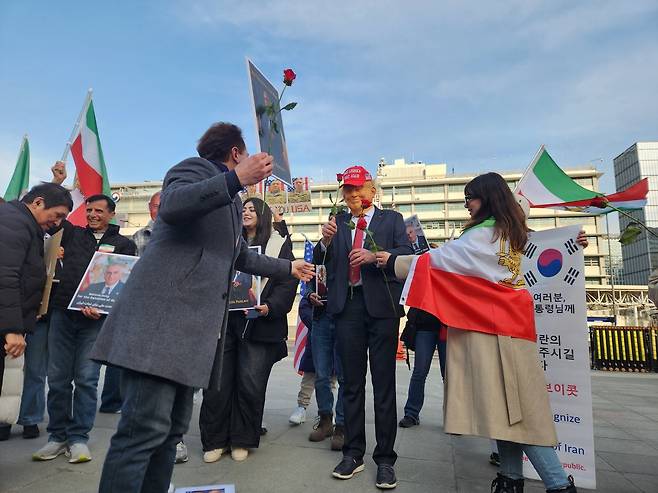 8일 오후 서울 종로구 주한미국대사관 인근에서 벌인 집회에서 도널드 트럼프 미국 대통령 꽃 선물 퍼포먼스 하는 재한이란인들 [촬영 홍준석]