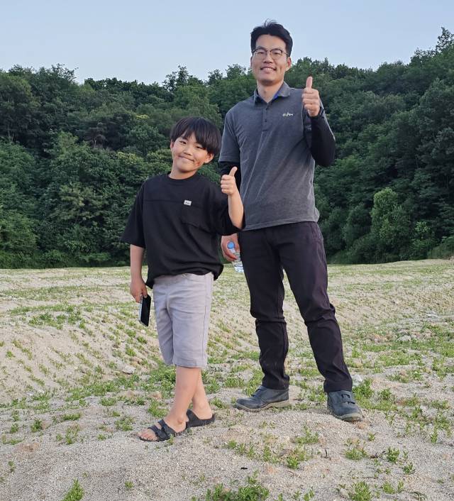 김태준 농부가 도라지밭에서 아들 김산아 군과 함께 엄지를 들어 올리고 있다.