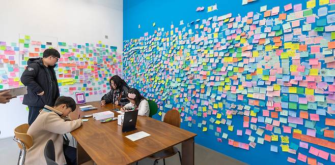 마지막 체험 공간에서 편지를 쓰고 있는 관람객들. 벽면에는 관객들이 붙인 포스트잇이 빼곡히 붙어 있다. /김지호 기자