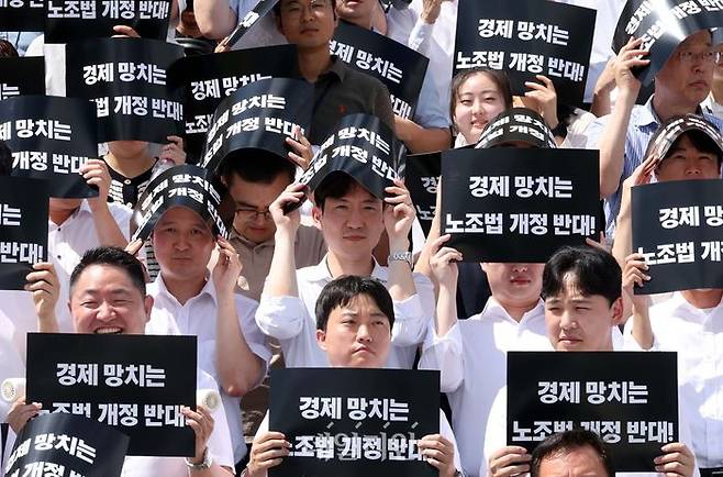 지난해 7월 19일 오후 서울 여의도 국회 본청 계단에서 열린 노동조합법 개정안 수정 촉구 경제계 결의대회에서 참석자들이 손피켓으로 햇볕을 가리고 있다. ⓒ뉴시스