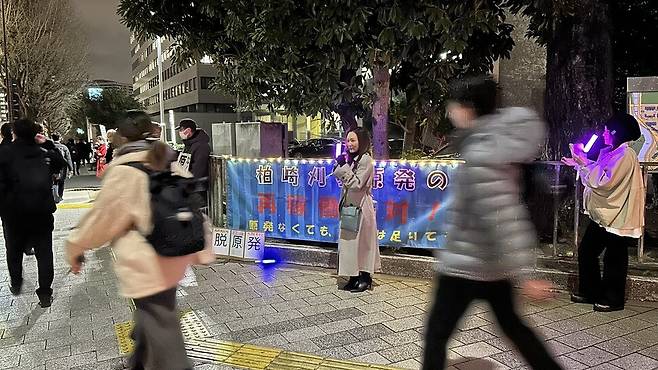 지난 6일 일본 도쿄 지요다구 총리 관저 앞 도로에서 시민단체 ‘가시와자키·가리와 원전을 재가동하지 마라 항의행동’이 집회를 여는 가운데 시민들이 스치듯 지나가고 있다.