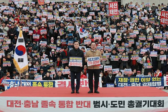 지난달 24일 김태흠 충남지사(왼쪽)와 이장우 대전시장이 국회 본청 앞 계단에서 열린 '대전·충남 졸속 통합 반대 범 시·도민 총궐기대회'에서 손팻말을 들고 있다. 연합뉴스