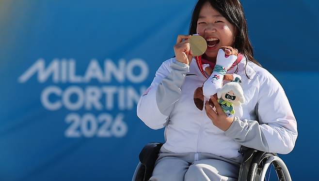8일(현지시간) 이탈리아 테세로 크로스컨트리 스타디움에서 열린 2026 밀라노·코르티나 동계 패럴림픽 파라 바이애슬론 여자 스프린트 좌식 12.5㎞ 시상식에서 한국 김윤지가 금메달을 목에 걸고 기뻐하고 있다. [연합]