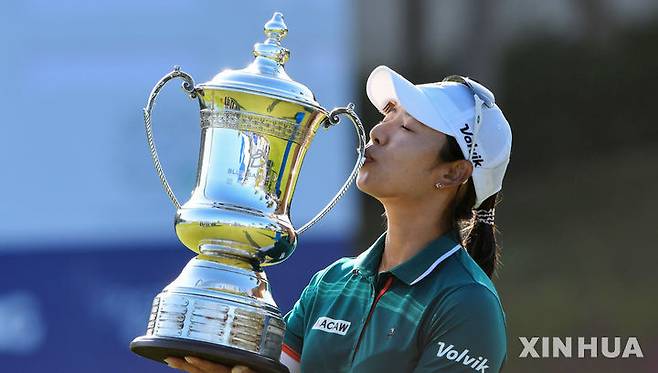 [링수이=신화/뉴시스] 이미향이 8일(현지 시간) 중국 하이난성 링수이의 지안 레이크 블루베이 골프클럽에서 열린 미국여자프로골프(LPGA) 투어 블루베이 LPGA 정상에 올라 트로피를 들고 입 맞추고 있다. 이미향은 최종 합계 11언더파 277타로 우승, 약 9년 만에 정상에 올랐다. 2026.03.09.