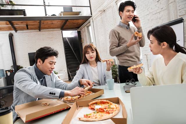 바쁜 직장인들이 간편식인 피자를 나눠 먹으며 일하는 것이 낯익은 풍경이 됐다. 게티이미지 뱅크