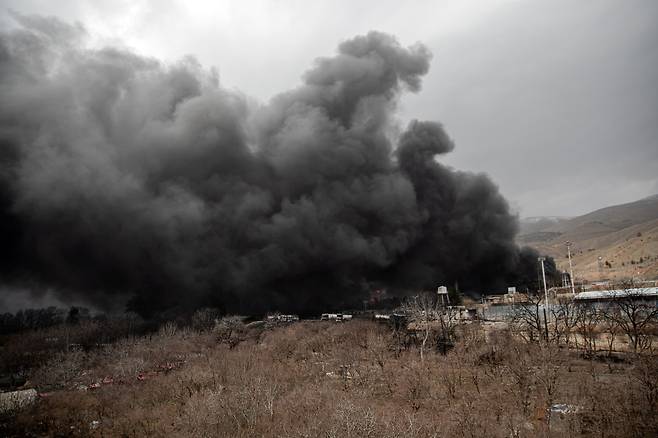 이란 수도 테헤란에서 석유 저장 탱크 위로 피어오르는 연기.(UPI/연합뉴스)