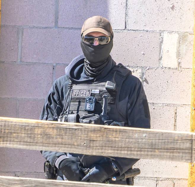 미국 뉴멕시코 산타페 인근 제프리 엡스타인의 ‘조로 목장’ 입구에서 무장 경비원이 주변을 경계하고 있다. 최근 목장 주변에서는 엡스타인 사건 피해자를 추모하는 도로변 추모물이 사라졌다는 보도가 나오며 논란이 이어지고 있다. AFP 연합뉴스