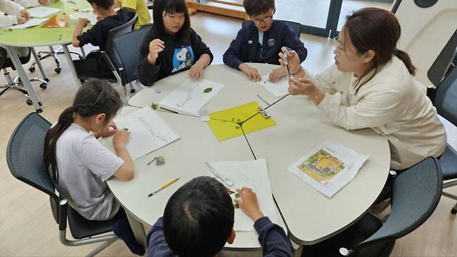 송산초 학생들이 '마을과 학교가 만나는 생태놀이'를 통해 학교 숲 생태 지도 그리기 등 자연활동을 체험하고 있다. 전남도교육청 제공