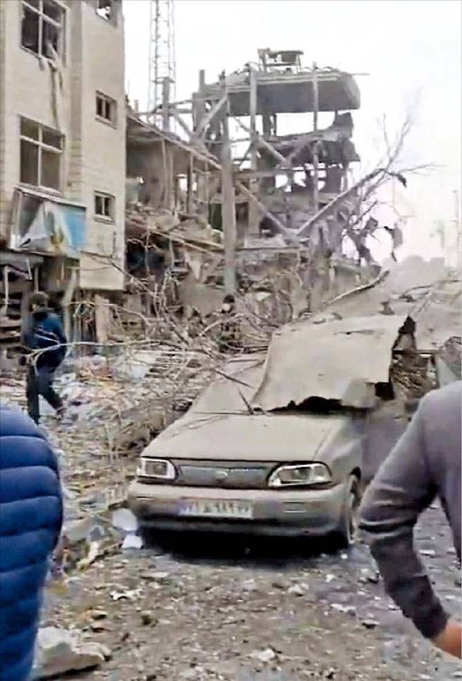 11일 이란 수도 테헤란 거리에 미국과 이스라엘의 공습으로 파괴된 건물과 차량의 잔해가 방치돼 있다./로이터 연합뉴스