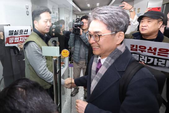 12일 오후 서울 양천구 한국방송회관 방송미디어통신심의위원회 회의실 앞에서 전국언론노동조합이 항의하는 가운데 김우석 위원이 회의에 참석하기 위해 지나가고 있다. 최현수 기자 emd@hani.co.kr