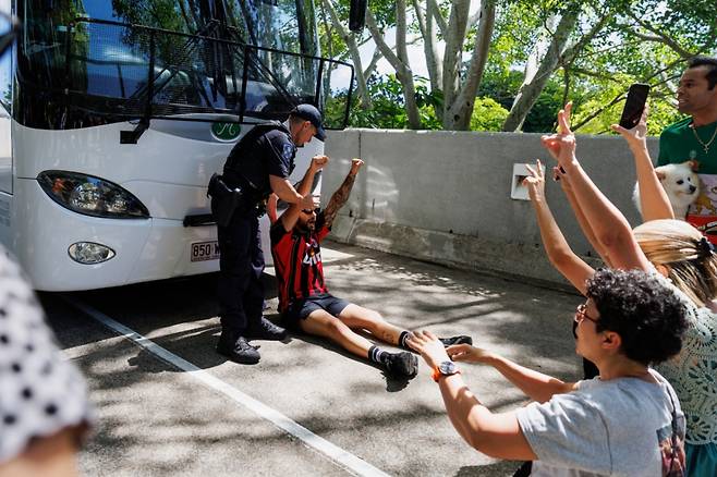 10일(현지 시간) 호주 골드코스트에서 한 경찰관이 이란 여자 축구대표팀이 탑승한 것으로 추정되는 버스의 이동을 막은 시위 참가자를 설득하고 있다./AP=뉴시스