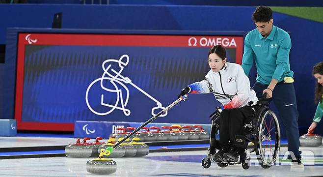 [코르티나담페초=뉴시스] 사진공동취재단 = 휠체어컬링 백혜진이 11일(현지 시간) 이탈리아 코르티나담페초 컬링 올림픽 스타디움에서 열린  2026 밀라노 코르티나 패럴림픽 휠체어컬링 믹스더블 중국과의 결승전에서 스톤을 밀고 있다. 2026.03.12. photo@newsis.com