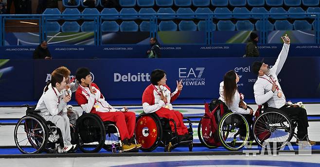 [코르티나담페초=뉴시스] 사진공동취재단 = 11일(현지 시간) 이탈리아 코르티나담페초 컬링 올림픽 스타디움에서 열린  2026 밀라노 코르티나 패럴림픽 휠체어컬링 믹스더블에서 시상식을 마치고 셀프카메라를 찍고 있다. 2026.03.12. photo@newsis.com