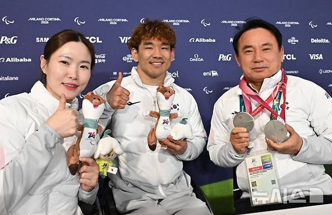 [코르티나담페초=뉴시스] 사진공동취재단 = 휠체어컬링 백혜진(왼쪽)과 이용석이 11일(현지시간) 이탈리아 코르티나담페초 컬링 올림픽 스타디움에서 열린  2026 밀라노 코르티나 패럴림픽 휠체어컬링 믹스더블에서 은메달을 차지한 뒤 윤경선 대한장애인컬링협회장에게 메달을 걸어주고 기념촬영 하고 있다. 2026.03.12. photo@newsis.com