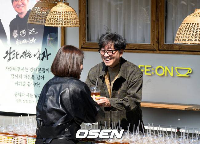 [OSEN=이대선 기자] 장항준 감독이 12일 오후 서울 중구 프레스센터 앞 광장에서 영화 '왕과 사는 남자' 흥행 감사 커피차 이벤트를 열었다.'왕과 사는 남자'는 개봉 36일째인 어제(11일) 관객수 1200만명을 넘어섰다. 이로써 '파묘'(1191만4869명)를 꺾고 역대 박스오피스 20위에 안착했다.장항준 감독이 커피차 이벤트를 진행하고 있다. 2026.03.12 /sunday@osen.co.kr