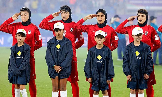 이란 여자축구대표팀 선수들이 8일 호주 골드코스트에서 열린 2026 아시아축구연맹(AFC) 여자 아시안컵 경기 시작 전 국가 연주 때 경례하고 있다. AFP연합뉴스