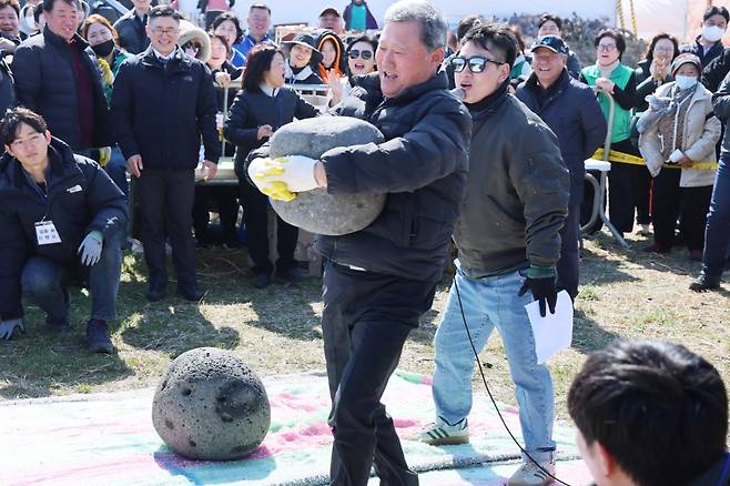 김완근 제주시장이 13일 제주들불축제 현장에서 듬돌돌기 행사에 참여했다. 듬돌은 '들어올리는 돌'이라는 뜻의 제주어로 성년이 된 마을 청년들이 듬돌을 들어올려 힘겨루기를 하던 전통에서 유래됐다.