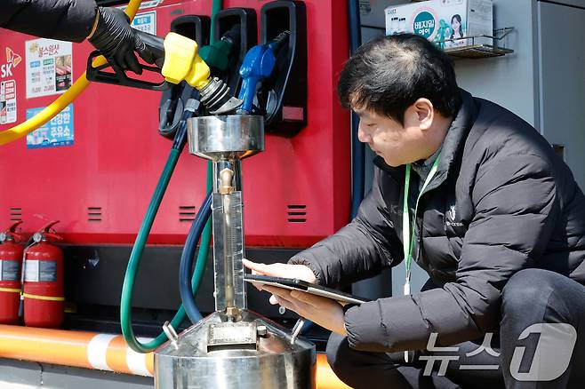 석유 최고가격제 시행 첫날인 13일 서울 마포구 SK에너지 양지주유소에서 한국석유관리원 관계자들이 정량기준탱크를 통해 휘발유 정량 확인을 하고 있다. ⓒ 뉴스1 안은나 기자