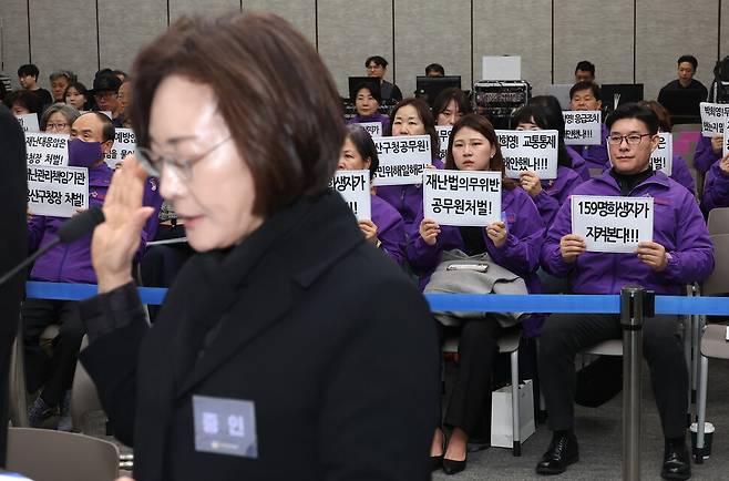 13일 서울 중구 은행회관에서 10·29 이태원참사 진상규명과 재발방지를 위한 특별조사위원회가 연 청문회에서 박희영 용산구청장이 증인선서를 하는 가운데 유가족들이 책임자 처벌을 촉구하는 손팻말을 들고 있다. 공동취재사진
