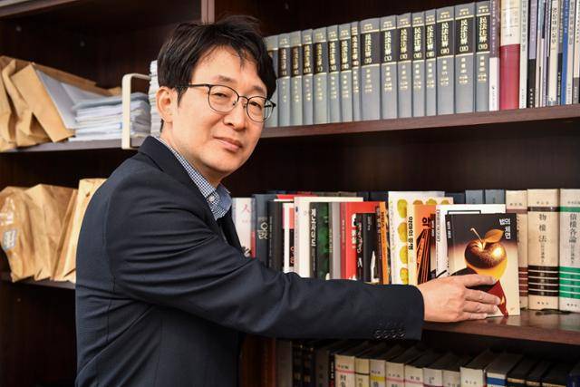 법복을 벗고 변호사로 개업한 도진기 작가가 9일 서울 서초구 사무실의 책장에서 법전 사이에 꽂혀 있는 추리소설을 빼내고 있다. 윤기훈 인턴기자