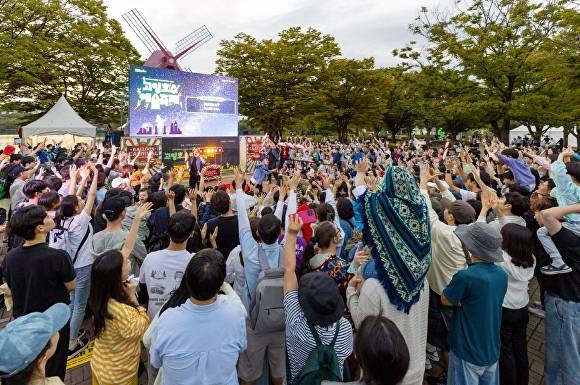 고양호수예술축제를 찾은 시민들이 두 손을 높이 들고 환호성을 지르며 거리예술가의 공연을 만끽하고 있다. [사진=고양문화재단]
