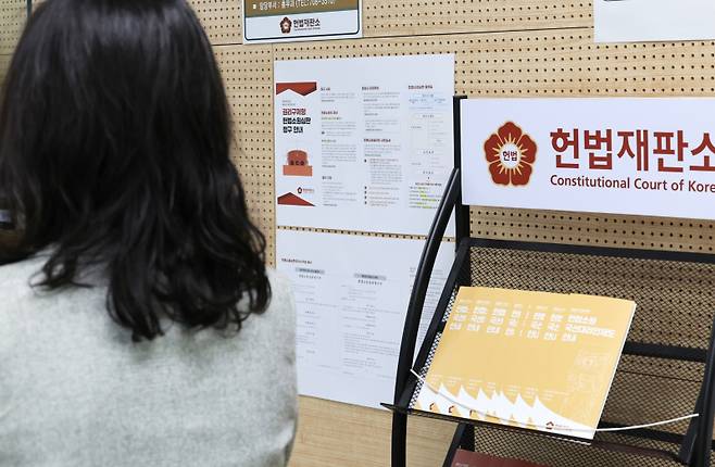 ‘최종심’인 대법원의 판결을 헌법재판소에서 다툴 수 있는 내용을 포함한 ‘사법개혁 3법’이 공표된 첫날인 12일 서울 헌법재판소 민원실에서 관계자들이 안내문 비치 등을 점검하고 있다. 연합뉴스