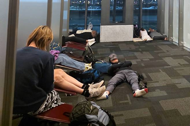 지난달 28일 이란 전쟁 발발 직후 모든 비행편이 취소된 카타르 도하 하마드 국제공항에서 발이 묶인 승객들이 맨 바닥에 누워 잠을 청하고 있다. [도하 이소연 기자]