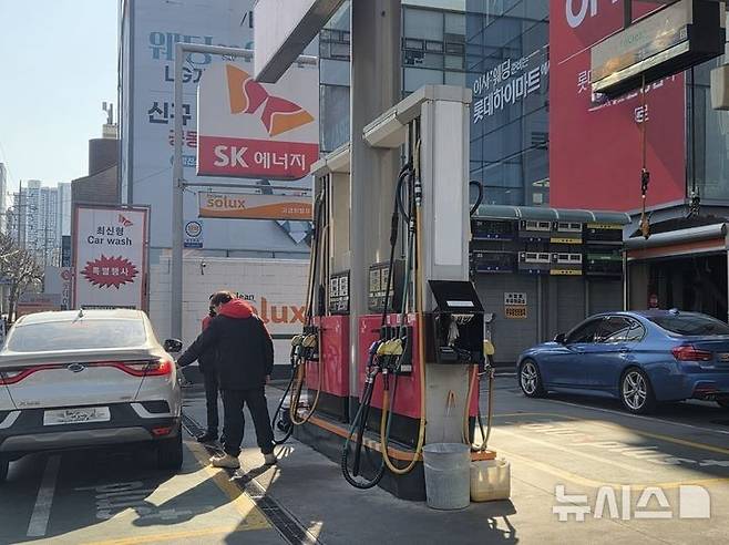 [서울=뉴시스] 이지영 기자= 석유 최고가격제가 시행된 첫날인 13일 서울 시내 한 주유소를 찾은 시민들이 주유하고 있다. 2026.03.13. jee0@newsis.com