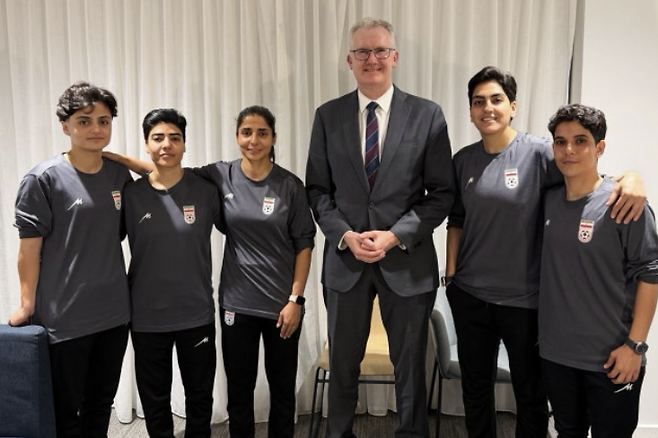 호주 토니 버크 내무장관(가운데)이 10일(현지시간) 공개되지 않은 장소에서 호주 망명을 허가받은 이란 여자 축구 선수 5명과 함께 기념촬영을 하고 있다. 호주 정부는 이들에게 인도주의 비자를 발급해 체류를 허용했다. 호주 내무부 제공