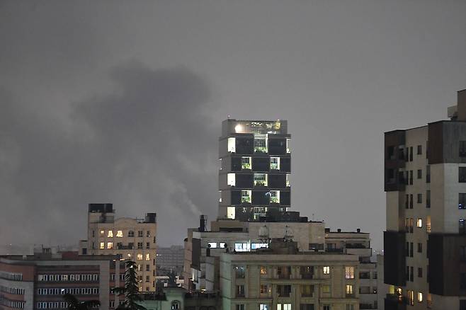 현지시간 13일 이란의 수도 테헤란에서 공습을 받은 건물에서 연기가 피어오르고 있다. 연합뉴스