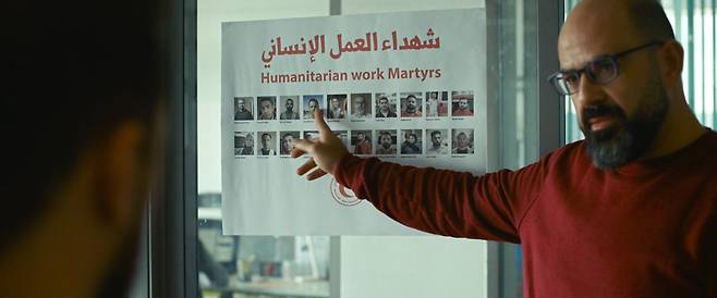 영화 '힌드의 목소리'의 한 장면. 팔레스타인 적신월사 간부가 이스라엘 군의 공격으로 구조 활동 중 사망한 구급대원들의 사진을 가리키고 있다. 사진 영화사 찬란