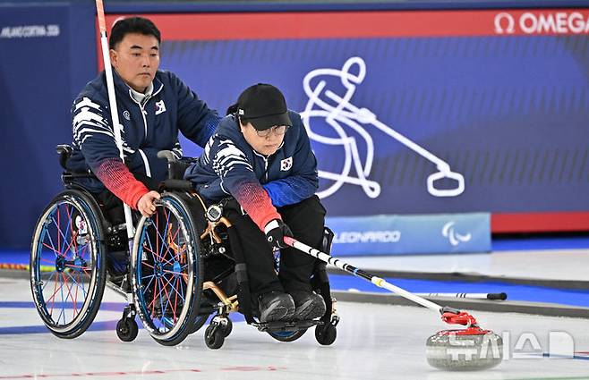 [코르티나담페초=뉴시스] 사진공동취재단 = 휠체어컬링 방민자가 13일(현지시간) 이탈리아 코르티나담페초 컬링 올림픽 스타디움에서 열린  2026 밀라노 코르티나 패럴림픽 휠체어컬링 혼성 4인조 캐나다와의 준결승전에서 스톤을 힘차게 밀고 있다. 2026.03.13. photo@newsis.com