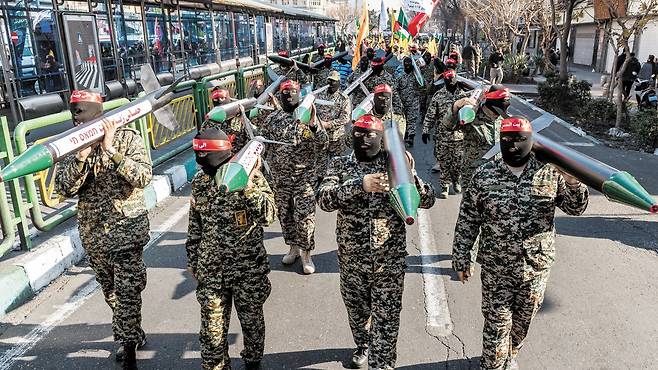 지난해 1월 이란 수도 테헤란 도심에서 검은 복면을 쓰고 붉은색 머리띠를 두른 이슬람혁명수비대(IRGC) 소속 바시즈 민병대 대원들이 미사일 모형을 들고 행진하고 있다. 미사일에는 ‘가자(Gaza)에 신이 함께한다’ ‘쿠드스(예루살렘)여 우리가 간다’ ‘하마스는 살아있다’는 문구가 적혀있다./게티이미지코리아