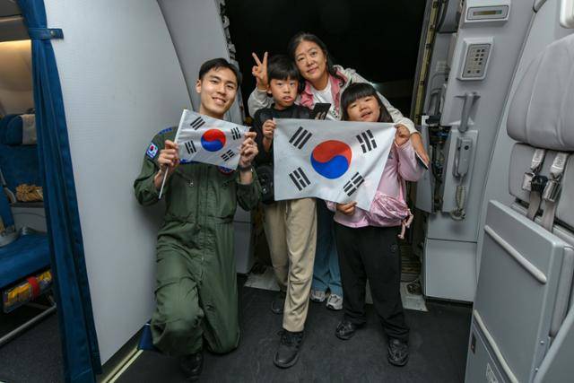 14일 중동 교민 대피를 위한 '사막의 빛' 작전으로 한국행 군수송기에 오른 국민과 공군 승무원이 태극기를 들고 있다. 외교부 제공