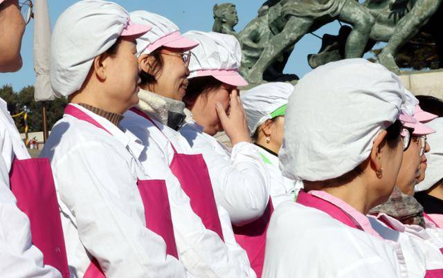 1월 29일 서울 여의도 국회 본청 계단에서 열린 '학교급식법 개정 환영' 기자회견에서 한 학교급식노동자가 눈물을 훔치고 있다. 뉴시스