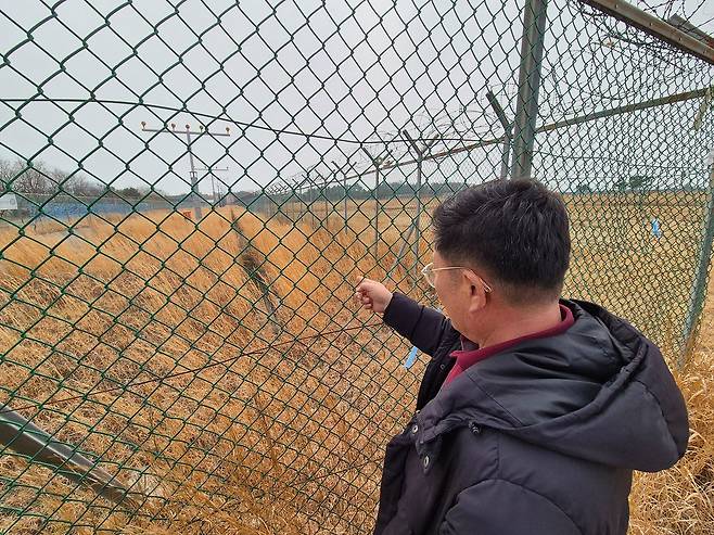 15일 전남 무안국제공항 활주로 인근에서 12·29 제주항공 여객기 참사 유족 이정근(60)씨가 유해 추정 물체가 발견된 지점을 가리키고 있다. 황희규 기자.