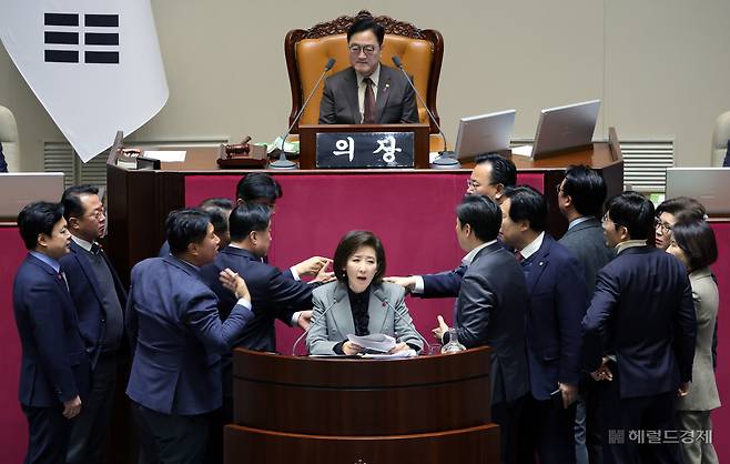 나경원 국민의힘 의원이 지난해 12월 9일 서울 여의도 국회에서 열린 본회의에서 무제한토론(필리버스터)을 하는 가운데 우원식 국회의장이 마이크를 끄자 의원들이 항의하고 있다. 이상섭 기자