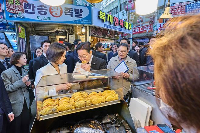 [서울=뉴시스] 최동준 기자 = 이재명 대통령과 김혜경 여사가 15일 경남 창원시 반송시장을 방문해 붕어빵을 맛보고 있다. (사진=청와대 제공) 2026.03.15. photo@newsis.com *재판매 및 DB 금지