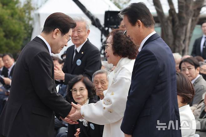 [창원=뉴시스] 최동준 기자 = 이재명 대통령이 15일 경남 창원시 국립 3.15 민주묘지에서 열린 제66주년 3.15의거 기념식에서 유족들과 악수하고 있다. 2026.03.15. photocdj@newsis.com