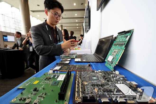 9일 서울 강남구 코엑스에서 열린 '삼성전자 파운드리 포럼'과 '세이프(SAFE) 포럼 2024' 행사에 앞서 유관 기업 관계자가 반도체 칩을 설명하고 있다. 삼성전자는 이날 포럼을 통해 국내 시스템반도체 생태계 강화 성과와 향후 지원 계획을 공개했다. 2024.7.9 ⓒ 뉴스1 장수영 기자