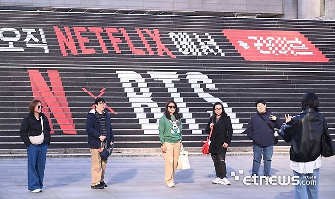 방탄소년단(BTS)의 컴백 라이브: ARIRANG 공연이 오는 21일 서울 광화문 광장에서 진행된다. 이날 공연은 넷플릭스를 통해 전세계로 생중계된다. 시민들이 세종문화회관 계단에 장식된 BTS 공연 홍보물앞에서 사진을 찍고 있다. 박지호기자 jihopress@