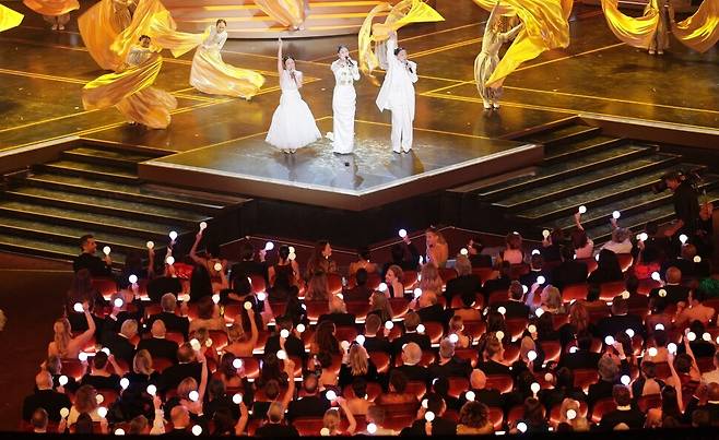 16일(한국시각) 미국 로스앤젤레스 돌비극장에서 열린 제98회 아카데미 시상식에서 ‘케이팝 데몬 헌터스’ 속 걸그룹 헌트릭스의 노래를 부른 가수들이 축하 무대에서 ‘골든’을 부르자 객석의 할리우드 스타 등 시상식 참가자들이 마치 케이팝 공연장에 온 것처럼 응원봉을 흔들며 리듬을 타고 있다. 로스앤젤레스/EPA 연합뉴스