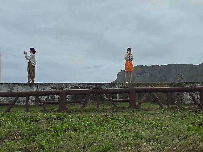 만세절벽의 일제 전범 장교 무덤의 제대에서 바다풍경을 촬영하고 있는 한국인 방문객들