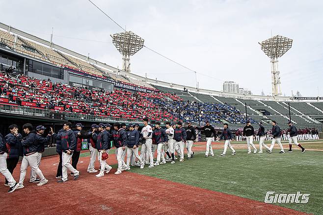롯데 자이언츠가 16일 부산 사직야구장에서 펼쳐진 키움 히어로즈와 2026 신한 SOL KBO 리그 시범경기 홈 경기에서 장단 17안타를 몰아친 끝에 12-1 대승을 거뒀다. 승리 후 코칭스태프와 하이파이브를 하는 롯데 선수단. /사진=롯데 자이언츠 제공