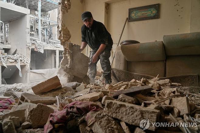 폭격당한 테헤란 아파트 (테헤란 AP=연합뉴스) 2026년 3월 15일 이란 수도 테헤란에서 폭격당한 경찰서 주변 아파트의 거주자가 잔해를 치우고 있다. (AP Photo/Vahid Salemi) 2026.3.16.