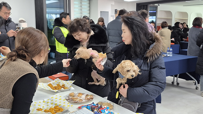 관음동물교육센터 개소식이 열린 22일 오후, 센터 1층 펫푸드 쿠킹실에서 반려견과 함께 방문한 주민들이 수제 간식을 받아보고 있다. 조윤화기자