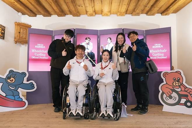 휠체어컬링 믹스더블 이용석, 백혜진이 코리아하우스에서 기념촬영을 하고 있다. 사진 | 대한장애인체육회