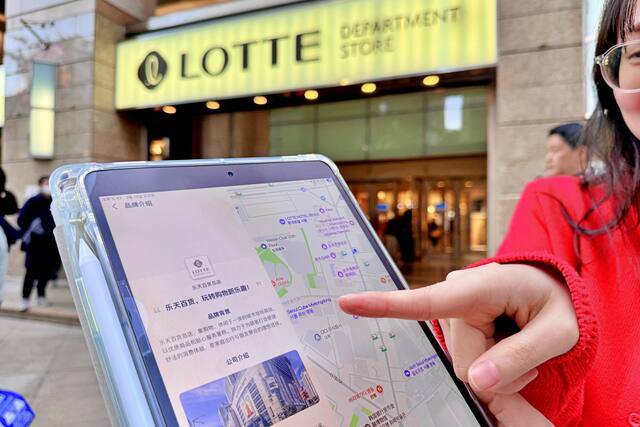 서울 중구 소공동에 위치한 롯데백화점 본점 앞에서 모델이 고덕지도 앱을 가리키고 있다. /롯데백화점