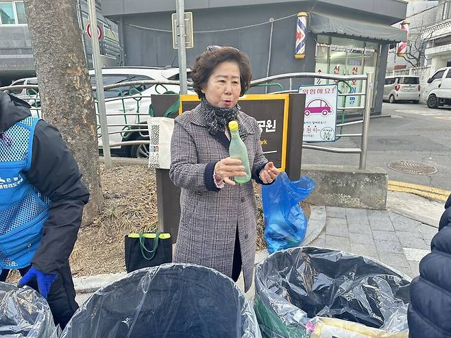 코디네이터 홍영희씨가 들기름이 담겨 있던 병이 지저분해 재활용이 안 된다고 말하고 있다. 은평구청 제공