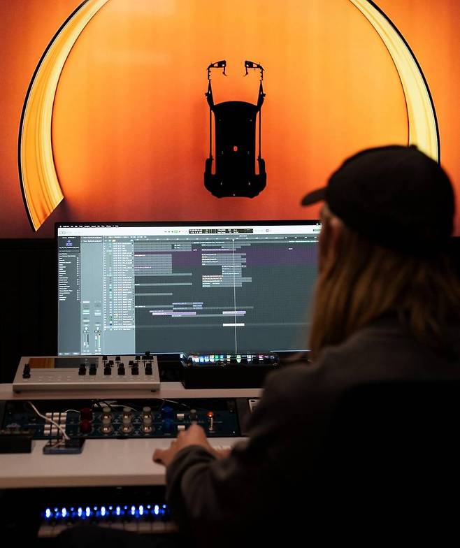 가상의 배기음인 E-사운드를 비롯해 차량 내부에 탑재할 음향 설비 등을 테스트하는 작업자의 모습 / 출처=지커